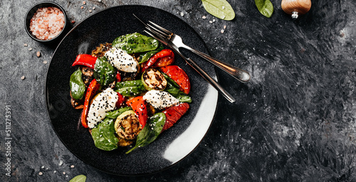 Delicious salad with roasted bell pepper, zucchini, eggplant with spinach leaves and feta cheese. Restaurant menu, dieting, cookbook recipe top view