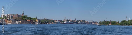 Panorama view over the bay Saltsjön with apartment houses in the district Nacka commuting boats and cruise ships a sunny summer day in Stockholm 