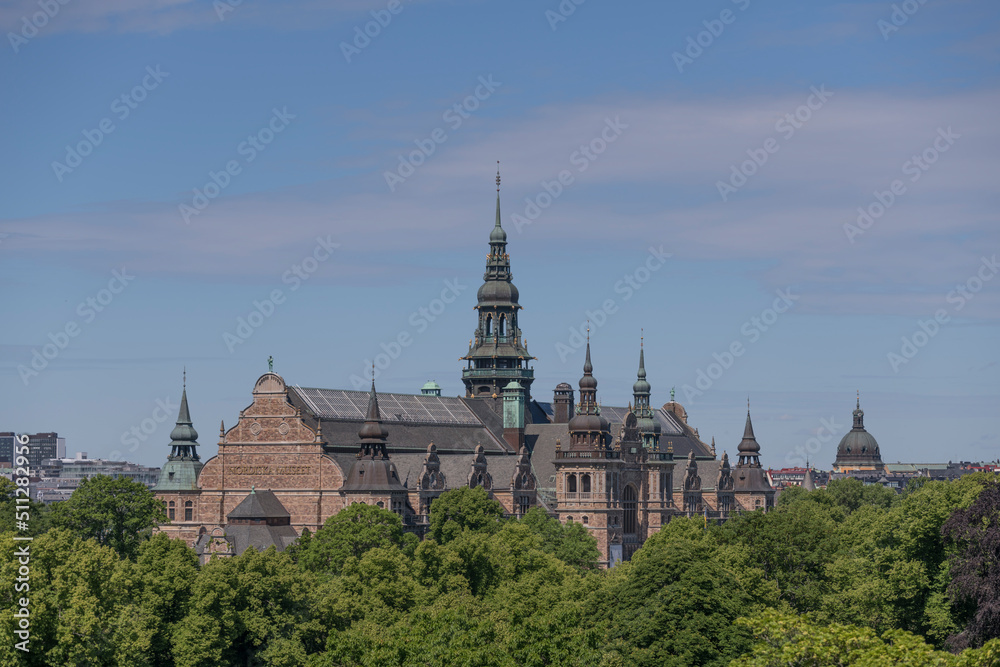 Old gothic museum building with towers and spires and trees a sunny summer day in Stockholm 