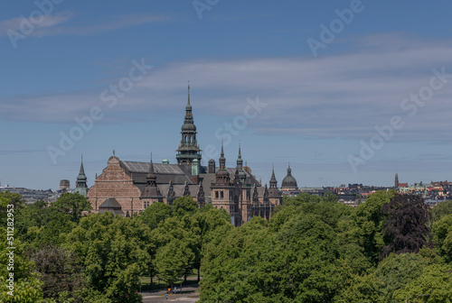 Old gothic museum building with towers and spires and the skyline of the districts Östermalm and Vasastan a sunny summer day in Stockholm 