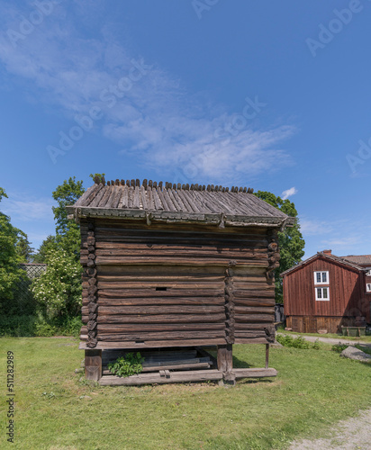 An old log storage building with birch roof in a park a sunny summer day in Stockholm