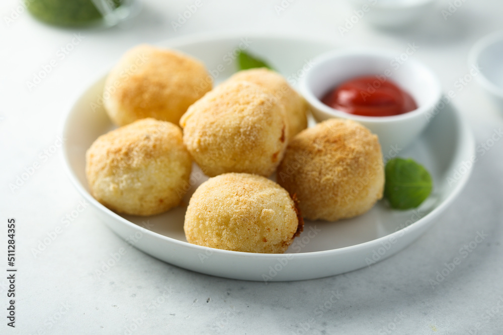 Traditional homemade arancini balls with tomato sauce Traditional homemade arancini balls with tomato sauce