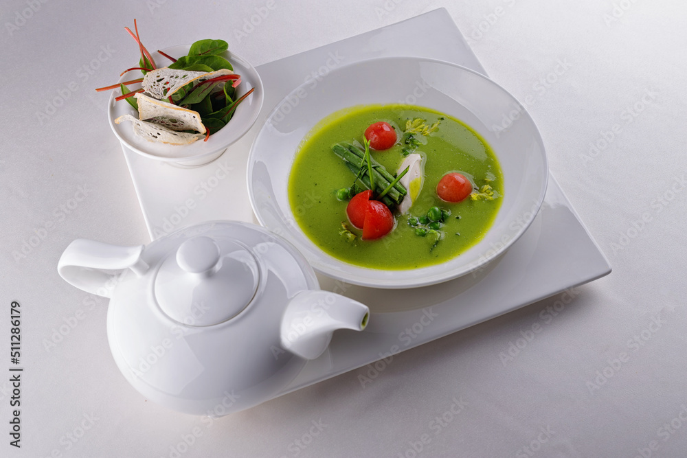 Cream soup of green peas with tomatoes, on a white background Cream soup of green peas with tomatoes, on a white background