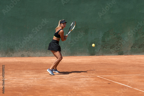 Young athletic tennis player playing a tennis match on a court