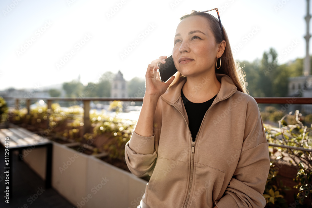 Portrait of beautiful young woman using smartphone on outdoor terrace in Istanbul