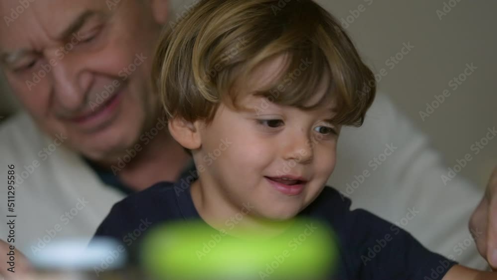 Child on grandfather lap grandpa lifting small boy candid family moment Child on grandfather lap grandpa lifting small boy candid family moment