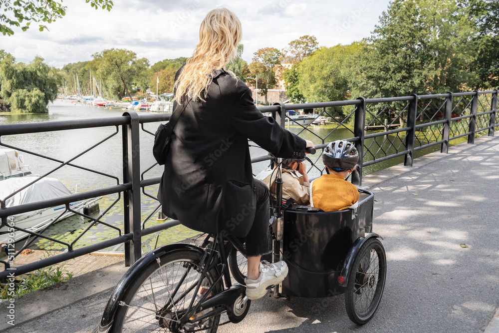 Mother riding bicycle with children in carriage Stock Photo Adobe Stock