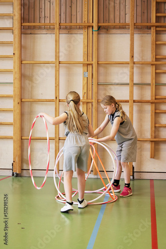Children playing with hula hoops in school gym
