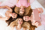 High angle top view photo of pretty sweet young ladies nightwear lying bed tacking selfie indoors house room