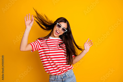 Photo of dreamy excited young lady wear red clothes dark glasses dancing isolated yellow color background