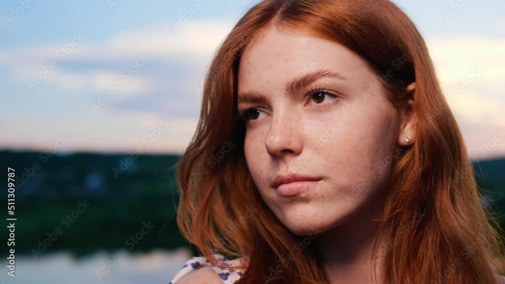 Portrait of Face Amazing Beautiful Red Haired Young Girl Posing on Background of the Lake Nature at Sunset. Natural Child Beauty. Female has Long Ginger Hair, Freckled. Brown Eyes. Woman Outdoor. Portrait of Face Amazing Beautiful Red Haired Young Girl Posing on Background of the Lake Nature at Sunset. Natural Child Beauty. Female has Long Ginger Hair, Freckled. Brown Eyes. Woman Outdoor.