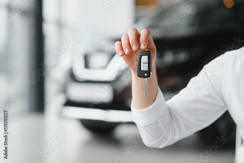 Man's hand holding modern car keys ready for rental. car buyer's hand with keys
