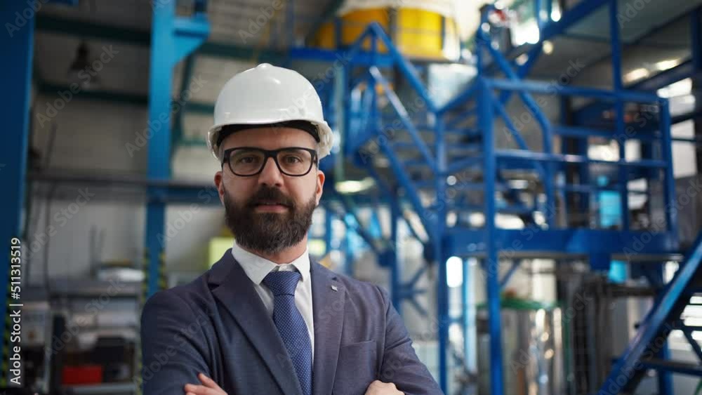Chief Engineer in the hard hat walks through industrial factory while holding tablet. Chief Engineer in the hard hat walks through industrial factory while holding tablet.