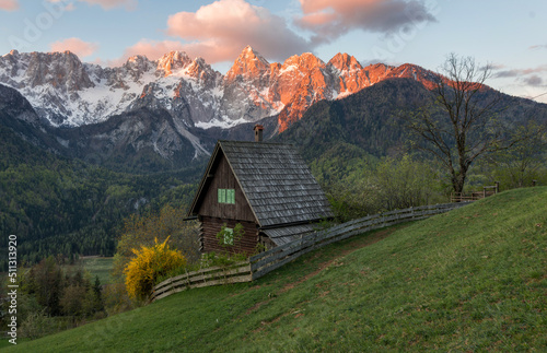 Sunrise in the mountains and hills in the spring with cottage and trees.