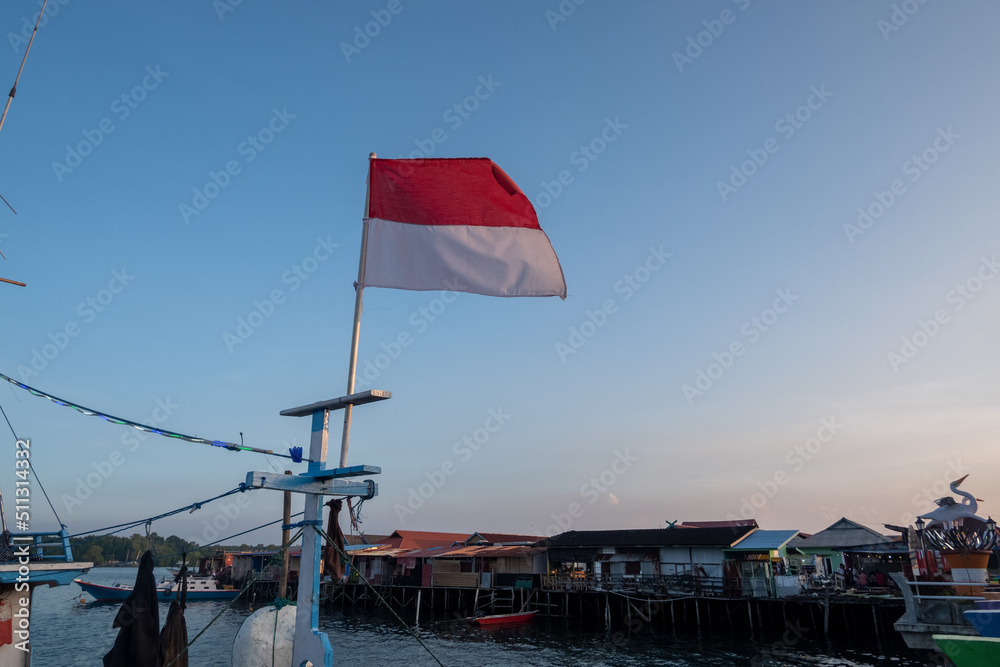 Indonesian red and white flag on a fishing boat with a blue sky