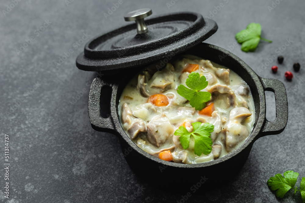 Chicken creamy stew in cast iron pot. Top view, copy space.