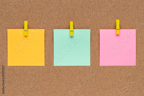 Three multicolor sticky notes on cork bulletin board, reminder important information. Blank square paper, modern template, frame. Planning concept.