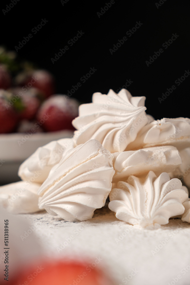 Meringue close up and strawberries in a plate on a black background. Fruit desserts. Meringue close up and strawberries in a plate on a black background. Fruit desserts.