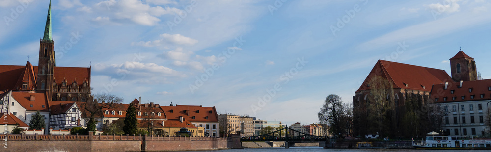 Bridge above river and buildings on Ostrow Tumski in Wroclaw, banner