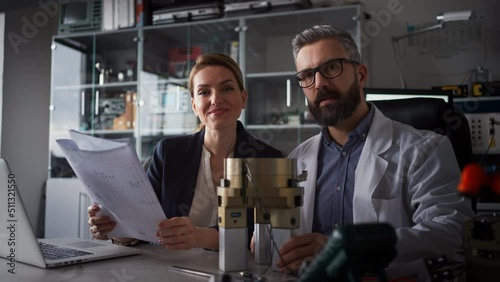 Robotics engineers working on laptop and desinging modern robotic arm in laboratory. photo