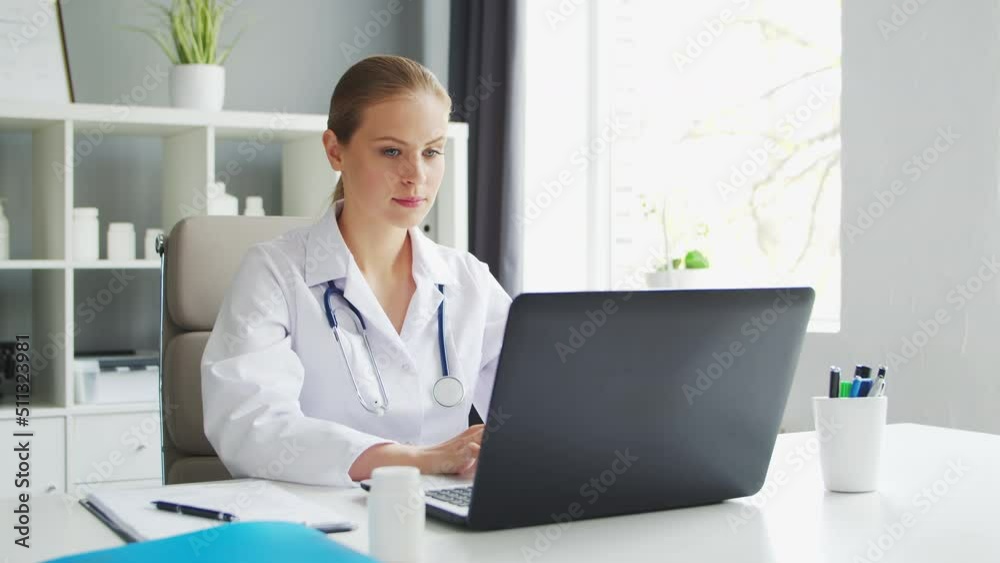 Doctor Works in the Medical Office. Woman in White Coat. Workplace of a Professional Female Therapist in a Hospital or Clinic. Healthcare and Medicine. Doctor Works in the Medical Office. Woman in White Coat. Workplace of a Professional Female Therapist in a Hospital or Clinic. Healthcare and Medicine.
