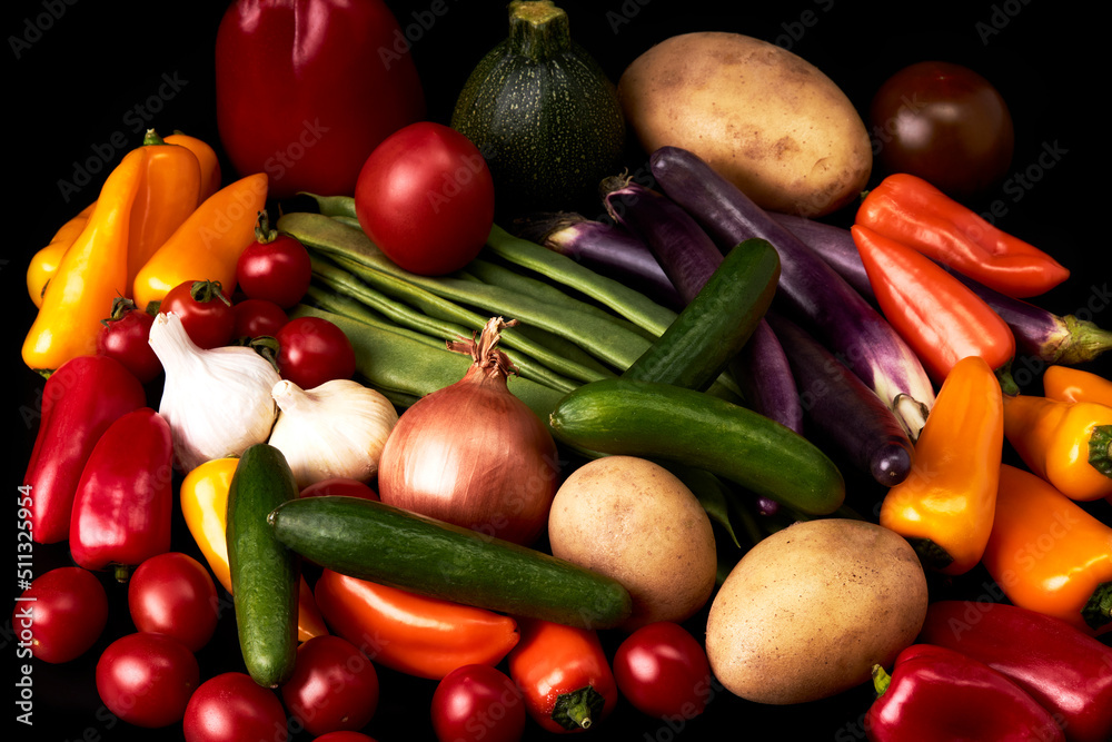 Variety of juicy vegetables on a black background. Vegetarian food