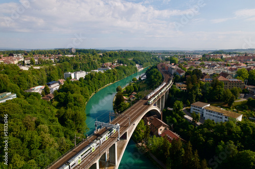 Foto Lorraine railway viaduct over River Aare with crossing trains at City of Bern, Capital of Switzerland, on a blue cloudy summer day