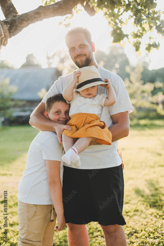 Fototapeta premium Happy father playing with his children outside in the park