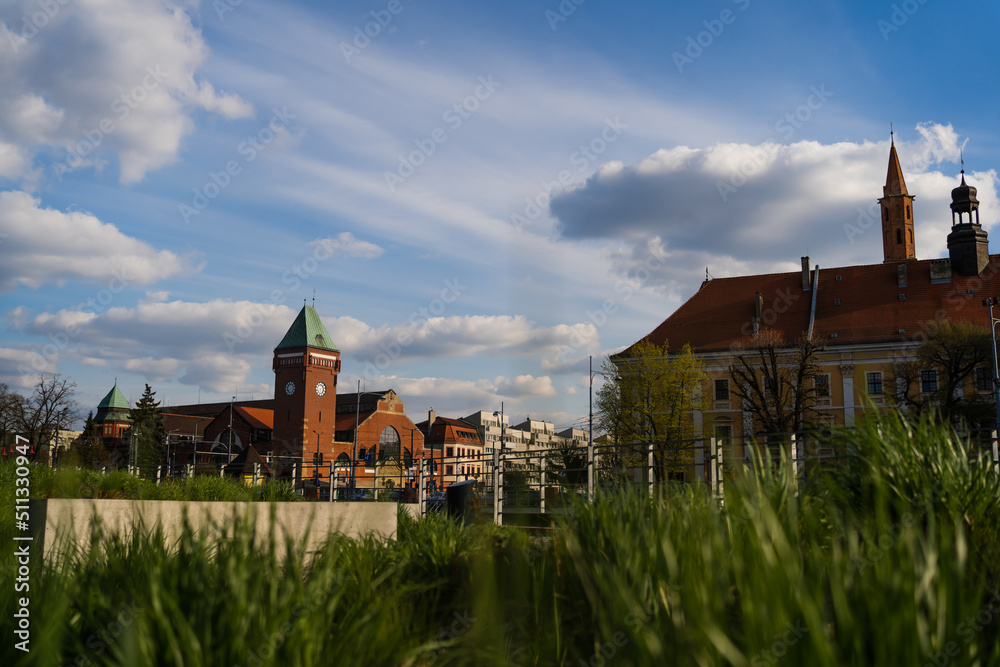 Buildings and Market Hall on urban street with cloudy sky at background in Poland