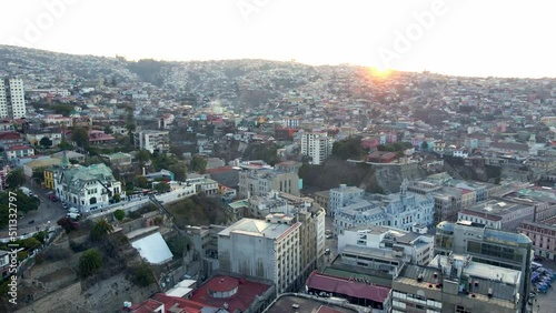 Aerial orbit in of Chilean Army building and Baburizza Palace in Cerro Alegre, Valparaiso hillside in background, Chile photo