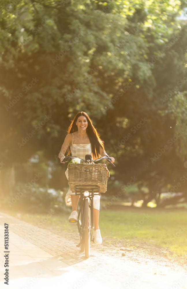 Young woman with flowers in the basket of electric bike
