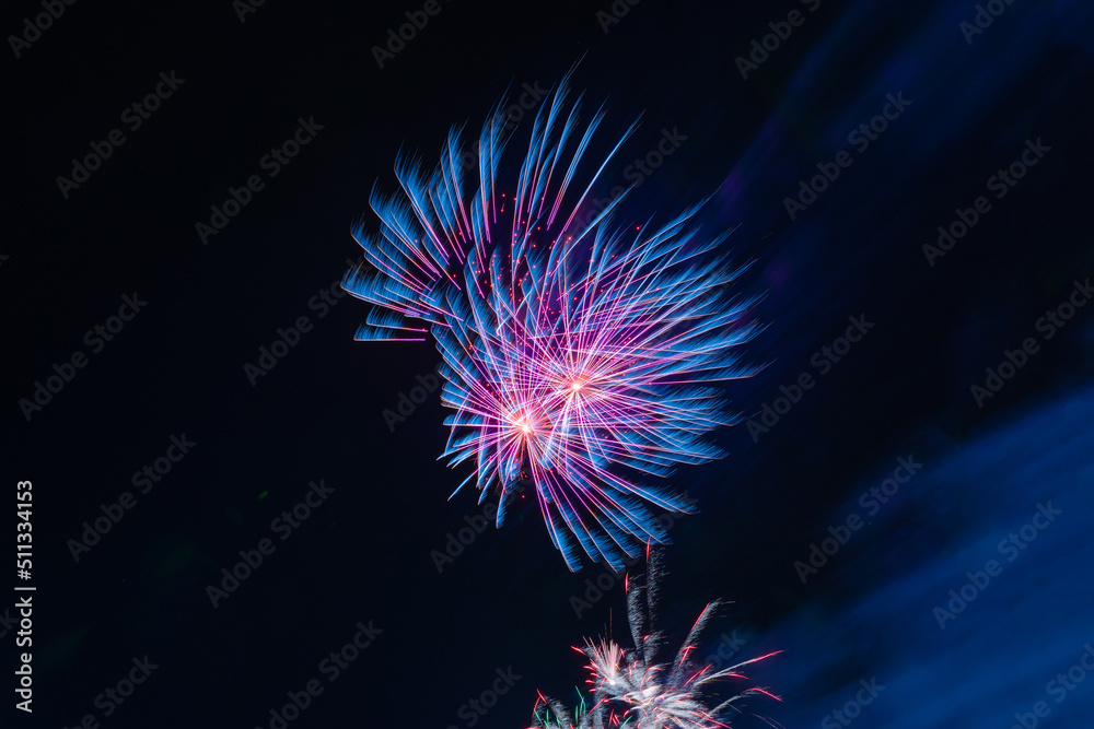 Bright and beautiful festive salute of red-blue color, with haze, in the night sky Bright and beautiful festive salute of red-blue color, with haze, in the night sky