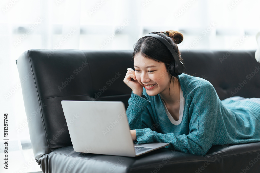 Beautiful smiling young woman in headphones chatting via laptop computer video call at home Beautiful smiling young woman in headphones chatting via laptop computer video call at home