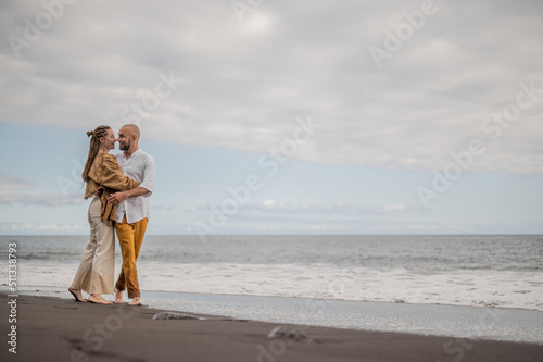 Young loving couple standing and hugging on a beach