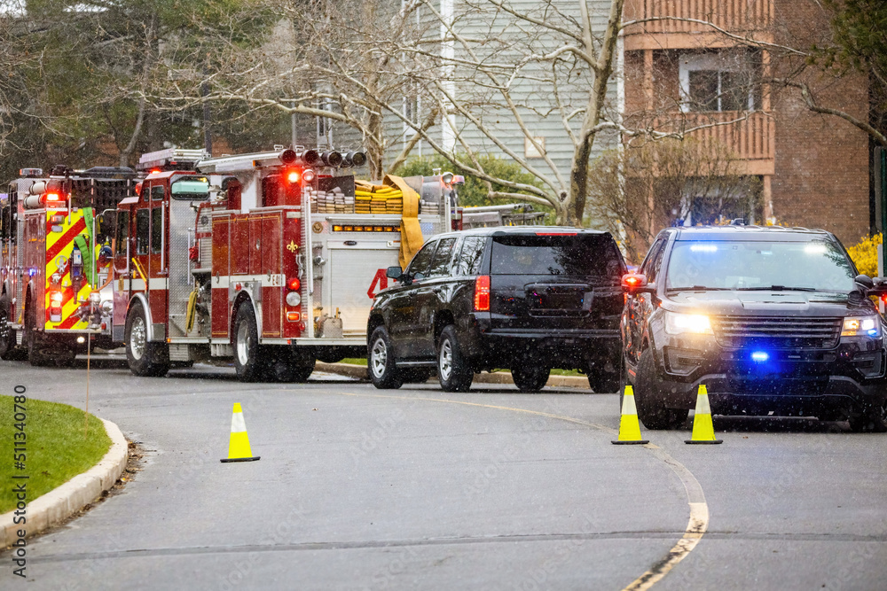 Police and emergency fire trucks on the street with lights on