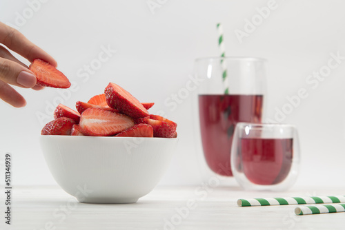 Red strawberries in hands with juice. Light background. Breakfast.