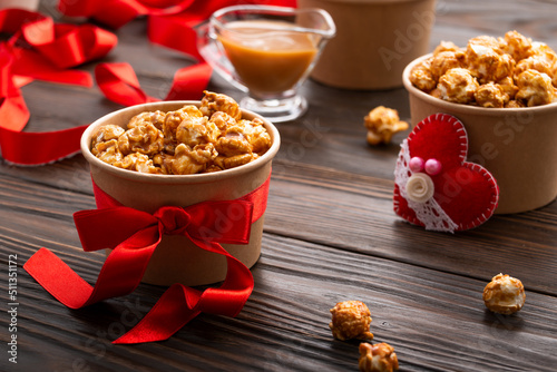Obraz na płótnie Carton buckets with caramelized popcorn and valentine decorations on kitchen table food background w salonie