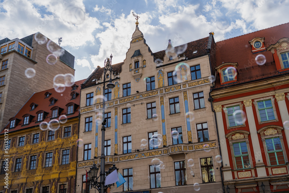 Fototapeta premium Low angle view of blurred soap bubbles on urban street in Wroclaw