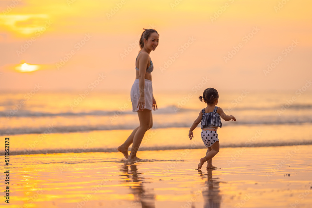 baby girl and mom with happy time run and walk play on beach in evening time with beautiful sunset light