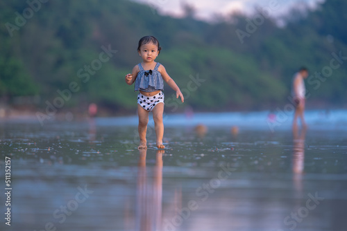 Fototapeta Naklejka Na Ścianę i Meble -  baby girl walking relaxing with happy time in evening time with beautiful sunset light
