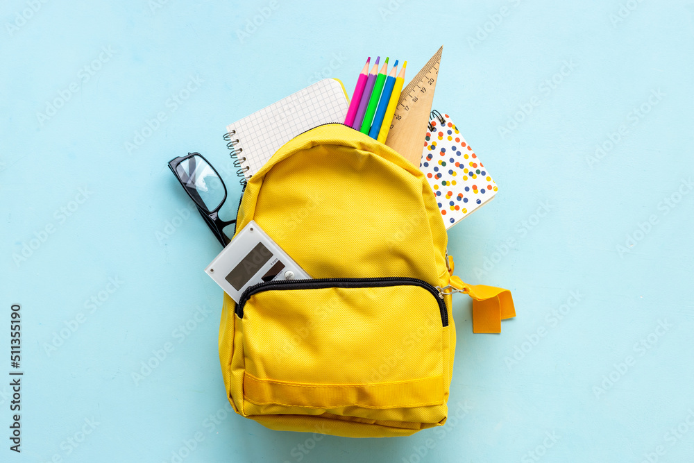 Naklejka premium School backpack with school items and students equipment, top view