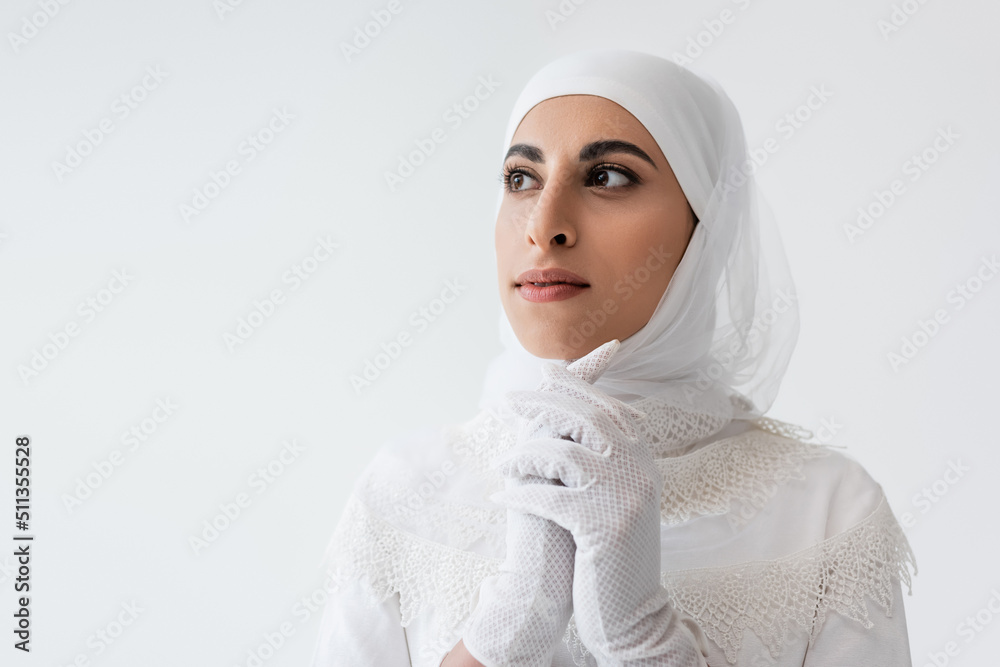 muslim bride in gloves and white dress praying isolated on grey. muslim bride in gloves and white dress praying isolated on grey.