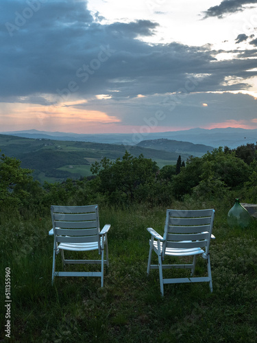 Two chairs and sunset over the hills in Tuscany, Italy. 