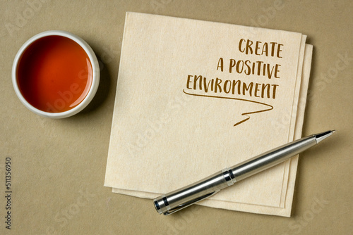 create a positive environment, inspirational reminder note on a napkin with a cup of tea, healthy lifestyle concept