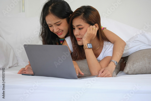 lgbtq lgbt concept homosexuality Two beautiful women happily express their love for each other playing laptop computers in their comfortable homes.