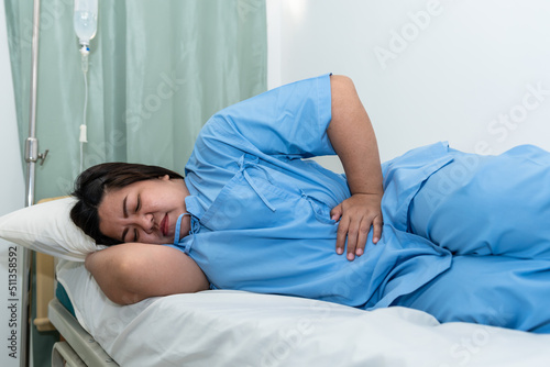 Asian fat woman patients lying in the  patient's bed, she had severe abdominal pain, From gastritis and enteritis, to people and health care concept.