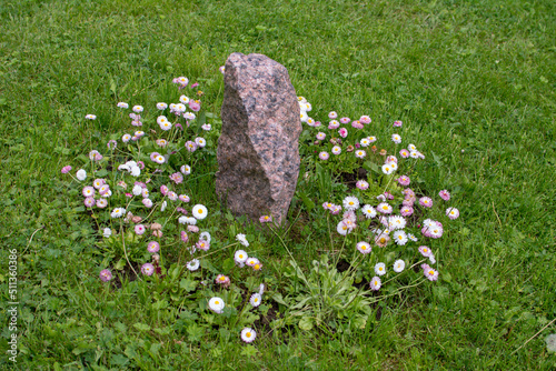 Granite stone stands on a green lawn