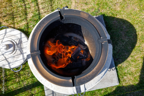 fire with charcoal in a compact home tandoor at the cottage photo