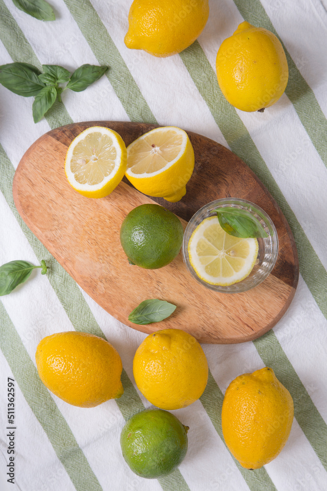 The ingredients for lemonade are on the table: lemons, lime, mint, sugar. A glass and a decanter of a refreshing summer seasonal drink. Making a drink at home. The ingredients for lemonade are on the table: lemons, lime, mint, sugar. A glass and a decanter of a refreshing summer seasonal drink. Making a drink at home.