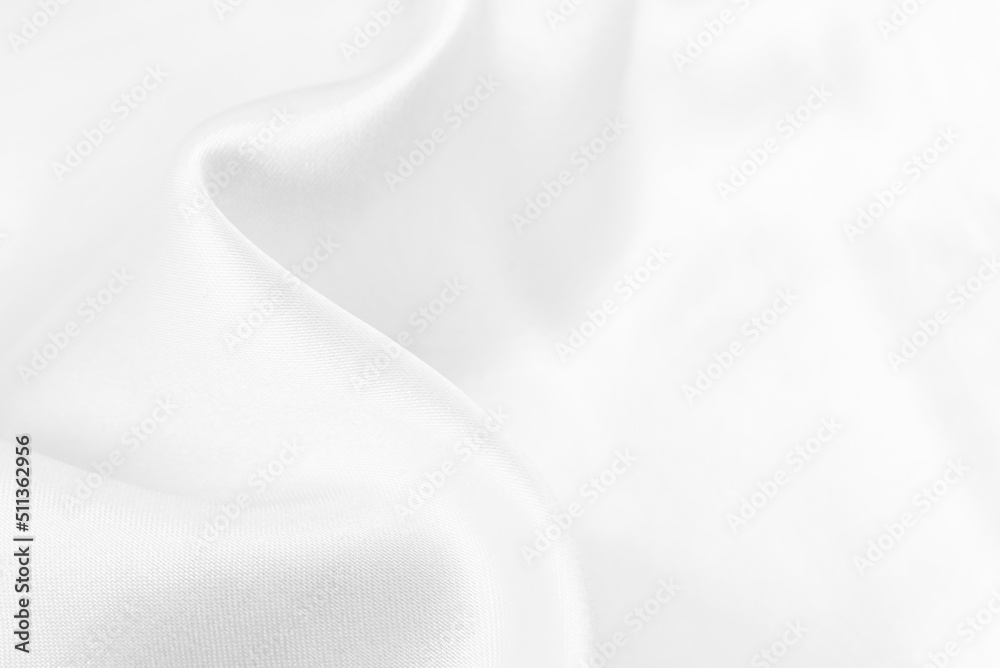 A twisted piece of white fabric. White material or texture with waves and folds. Wrinkled white fabric